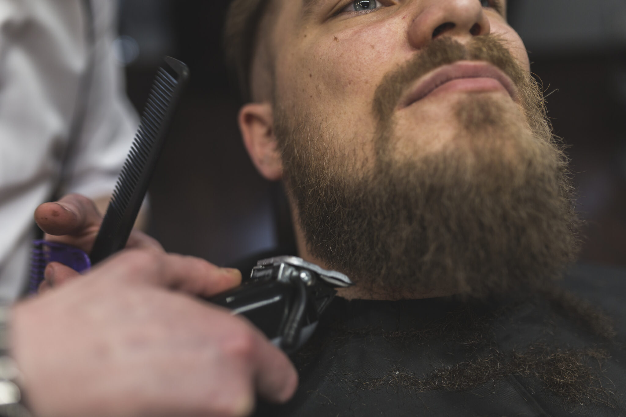close-up-barber-trimming-beard-man