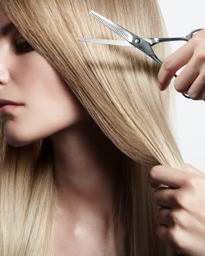 closeiup portrait of a woman with a hand holding scissors