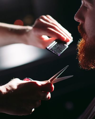Confident man visiting hairstylist in barber shop.
