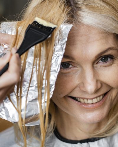 smiley-woman-getting-her-hair-dyed-by-hairdresser-home