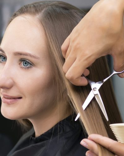 Womens hairdresser, beauty salon. Professional stylist cuts female hair in salon